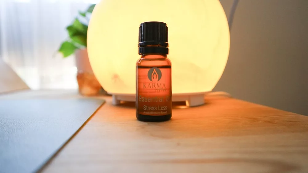 A small essential oil bottle in front of a diffuser.